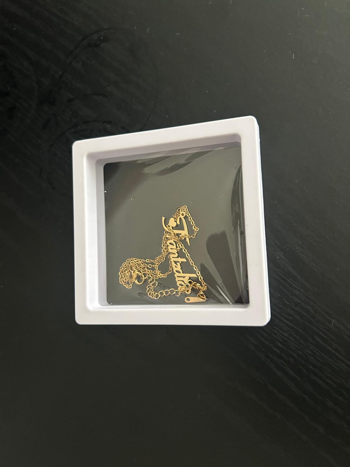 Gold script name necklace in a floating display box